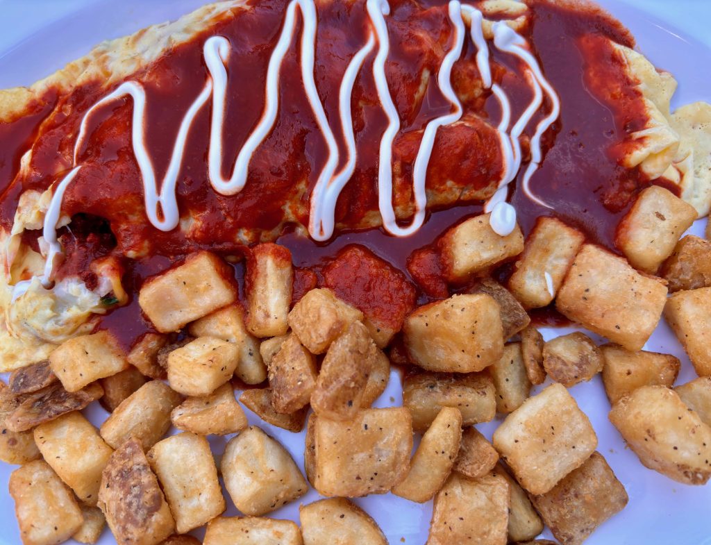 Gluten-free Mexican omelette with red sauce and breakfast potatoes.